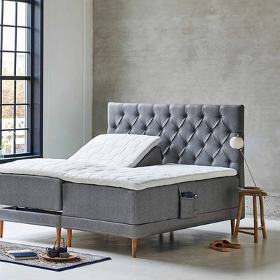 Chest sengegavl i bredde 140 cm betrukket med stof i grå farve.