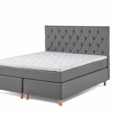 Chest sengegavl i bredde 140 cm betrukket med stof i grå farve.