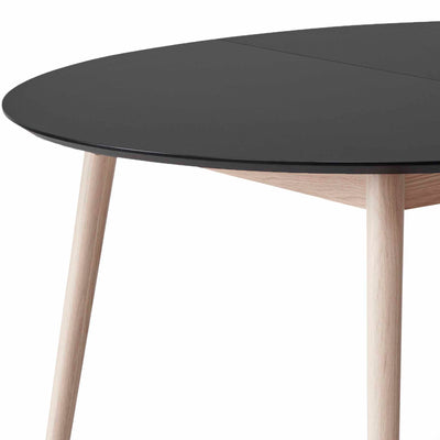 Meza by Hammel Round spisebord med bordplade i sort nano laminat med ben i massivt egetræ.