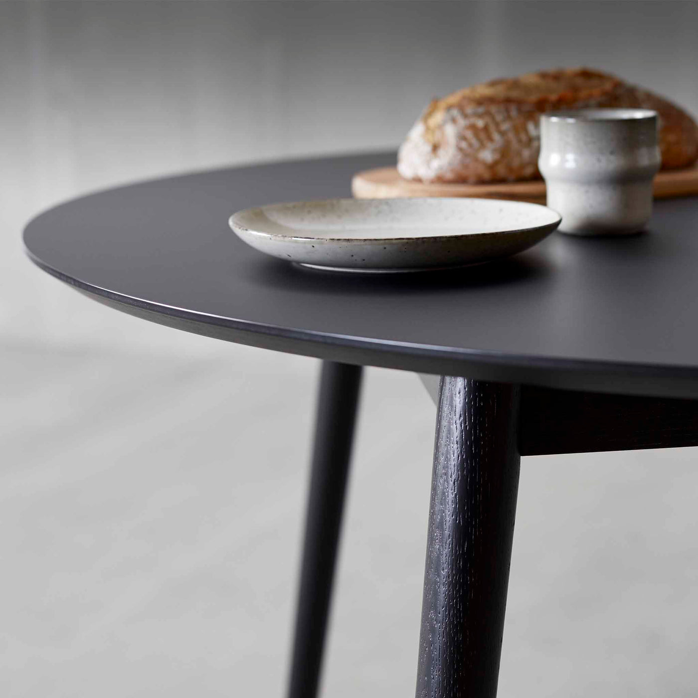 Meza by Hammel Round spisebord med bordplade i sort nano laminat med ben i sortbejdset ask.